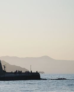 Silhouette boat in sea against clear sky