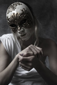 Midsection of woman holding mask