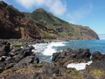 Scenic view of rocks in sea against sky