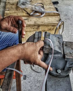 Midsection of man working on metal structure