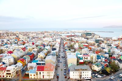 High angle view of cityscape by sea against sky