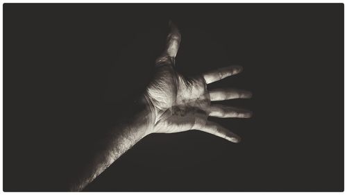 Close-up of hand against black background