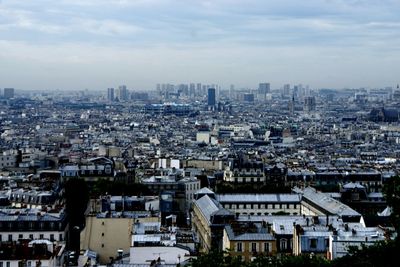 Cityscape against cloudy sky