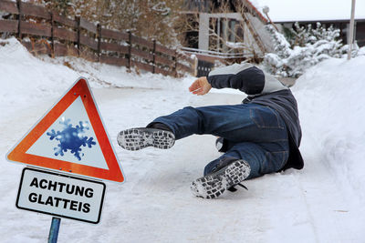 Rear view of man sitting on snow