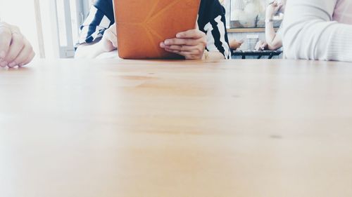 Mid section of woman sitting on table