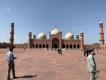 People at temple against clear sky