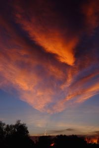 Low angle view of silhouette trees against dramatic sky