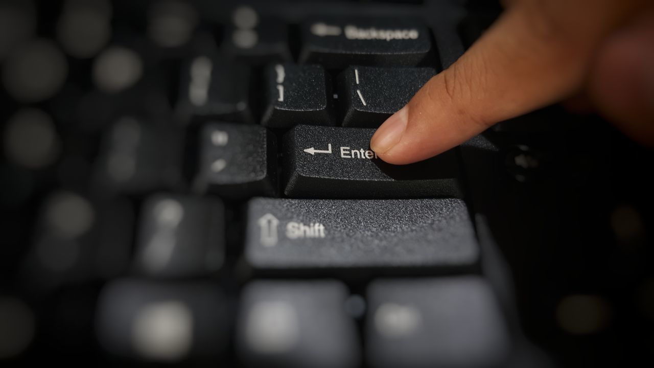 CLOSE-UP OF PERSON USING LAPTOP