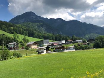 Houses on field by mountains against sky