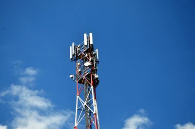 Low angle view of communications tower against blue sky