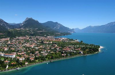 Aerial view of townscape by lake garda against sky