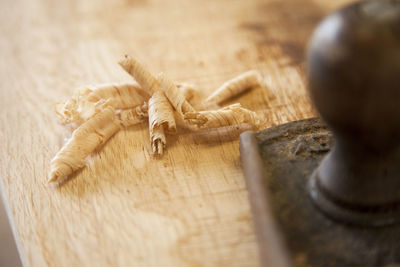 Close-up of chisel with shavings on wood