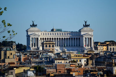 Buildings in city against clear sky