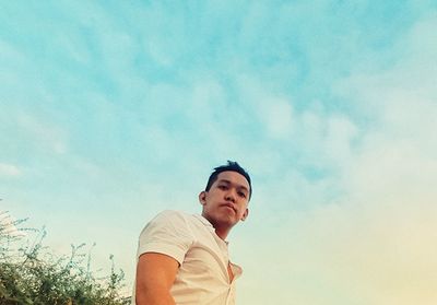 Low angle portrait of man against sky