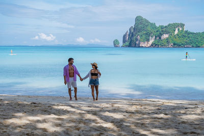 People on beach against sky