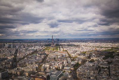 Aerial view of cityscape against cloudy sky