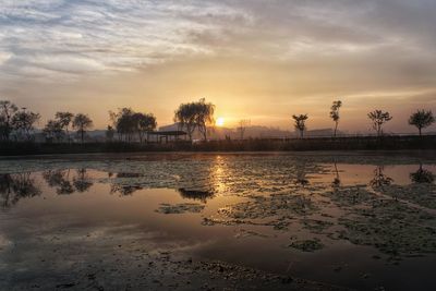 Scenic view of lake against sky at sunset