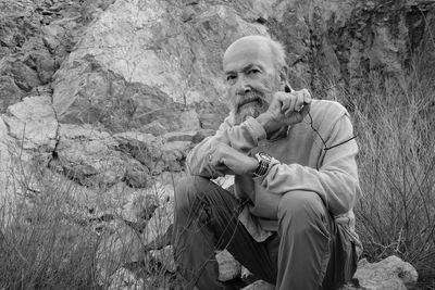 Young man sitting on rock