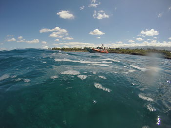 People sailing in sea against sky