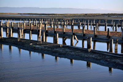 Wooden pier on beach against sky