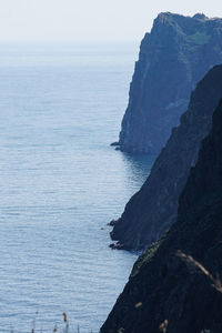 Rock formation in sea against sky