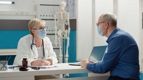 Side view of doctor examining patient in office