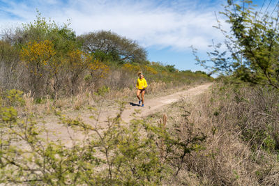 Man and plants on land against sky