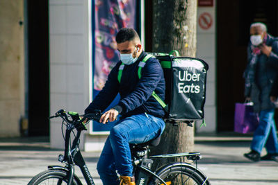 Man riding bicycle on street in city