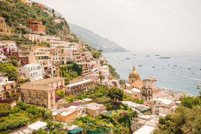 High angle view of townscape by sea against sky