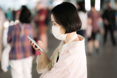 Side view of woman holding smart phone
