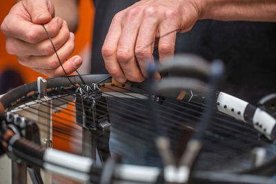 Cropped hand of man making racket outdoors