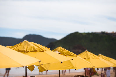 Yellow umbrella on beach against sky