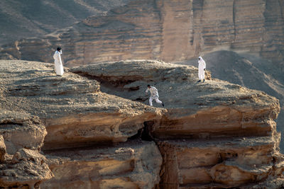 Middle eastern people standing on mountain during sunny day