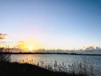 Scenic view of lake against sky during sunset