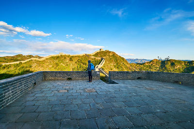 Man looking at view while standing at great wall of china against sky