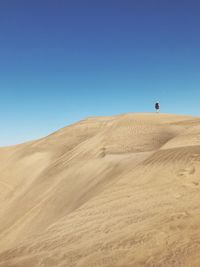 Scenic view of desert against clear blue sky