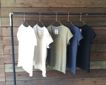 T-shirts hanging against wooden wall