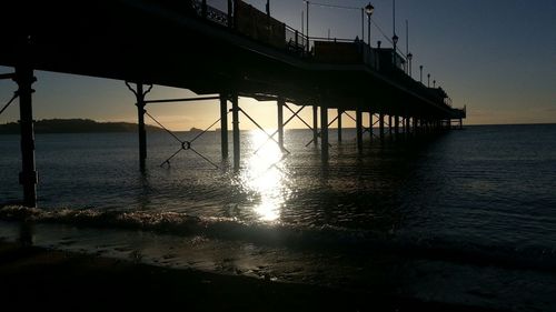 Pier on sea at sunset