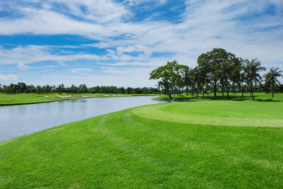 Scenic view of golf course against sky