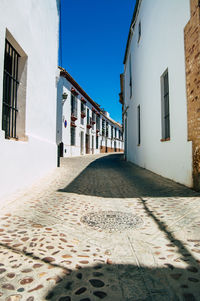 Surface level of footpath amidst buildings against sky