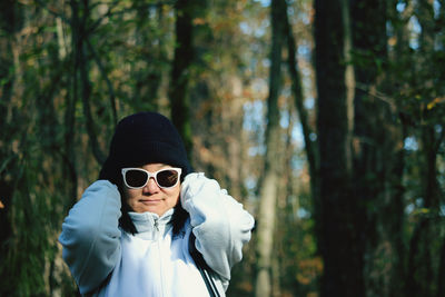 Portrait of man wearing sunglasses standing in forest