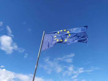 Low angle view of european union flag against blue sky on the wind