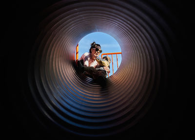 Mom and son viewed from the bottom of a slide tube