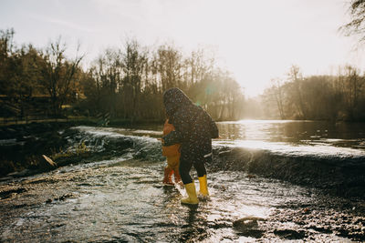 Rear view of woman walking on puddle