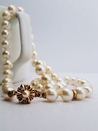 Close-up of necklace on white table