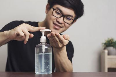 Portrait of man holding eyeglasses on table