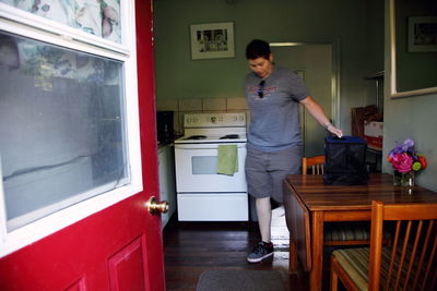 Woman standing by table in kitchen