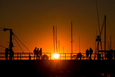 Silhouette people playing at sunset