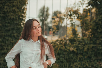 Smiling woman with eyes closed standing outdoors