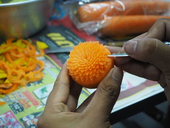 Close-up of hand holding orange